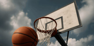 Basketbal die door professionele Britse basketballers richting een hoop wordt gegooid.