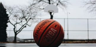 an nba basketball laying on a blacktop surface
