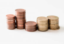 Stacks of copper and gold coins arranged in ascending order on a white background.